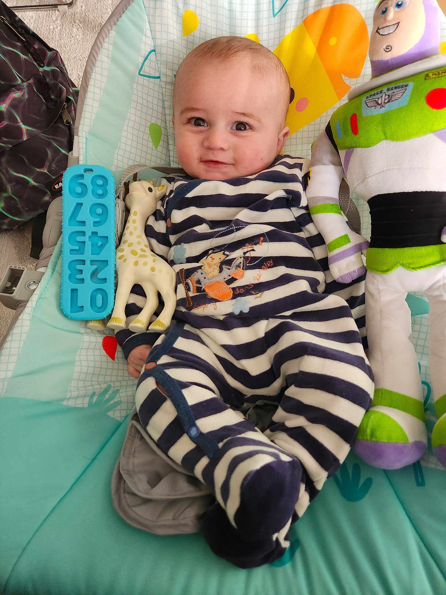 Mehdi a rejoint le concours — aidez-le/la à gagner de superbes lots ! baby, infant, striped_clothing, onesie, smile, face, toys, plush_toy, buzz_lightyear, giraffe_teether, baby_seat, colorful, cute, happy, child, indoor, playful, comfort, young, person