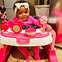 baby, child, cute, disney, face, floor_tiles, happy, headband, indoor, infant, kitchen, mickey_mouse, person, pink_clothing, playful, seat, smiling, toy, walker, young_child