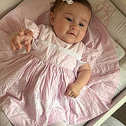 Emmelyn-Mae joined the competition — help win amazing prizes! baby, child, pink_dress, bow, crib, toddler, white_lace, hand, reaching, cute, soft_lighting, fabric, sleeping_area, infant, portrait, clothing, person, indoors, baby_clothes, closeup