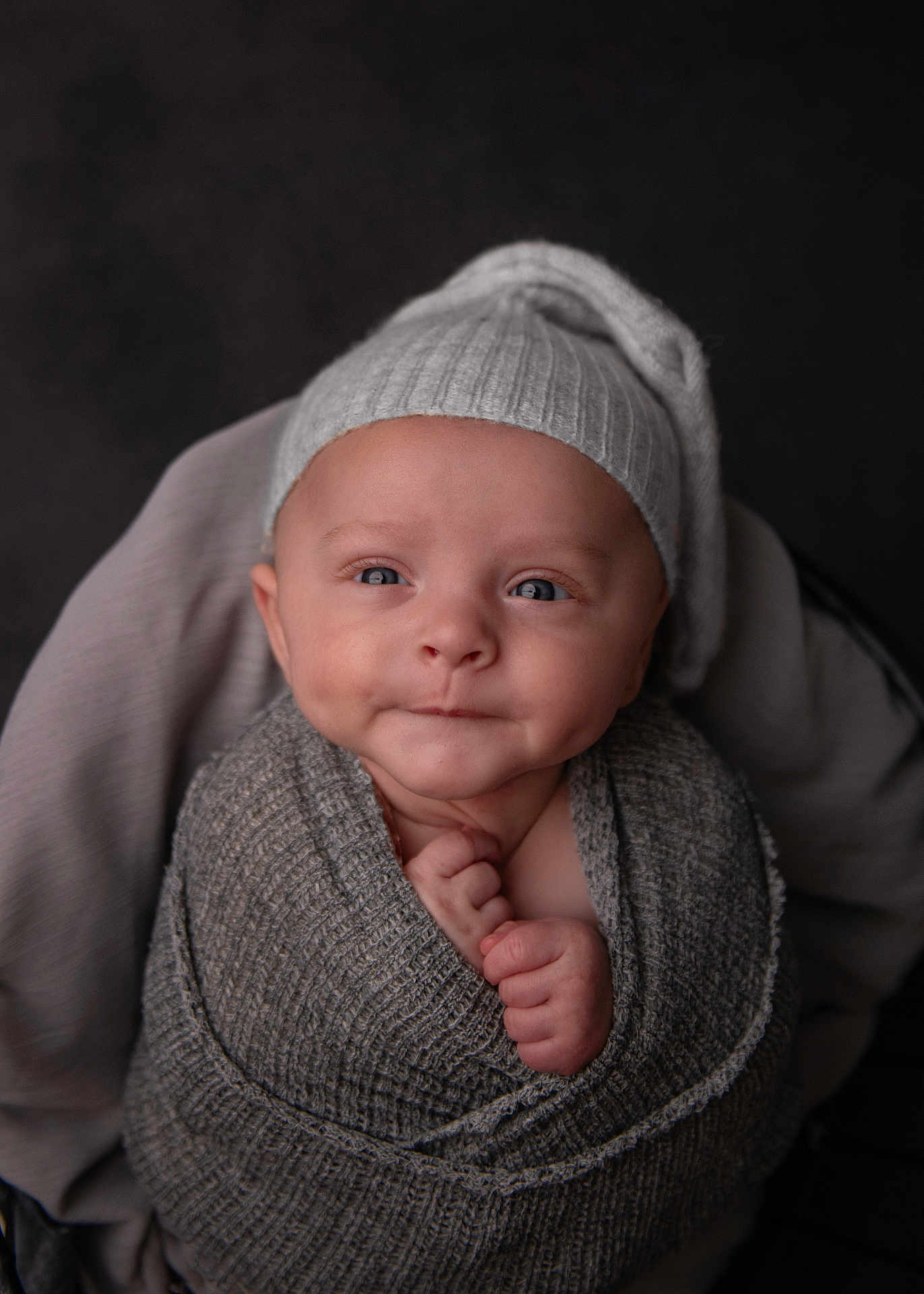 Wyatt joined the competition — help win amazing prizes! baby, infant, face, hat, knitted, blue_eyes, wrapped, cozy, portrait, cute, smile, child, newborn, soft_texture, warm, hands, closeup, expression, indoor, person