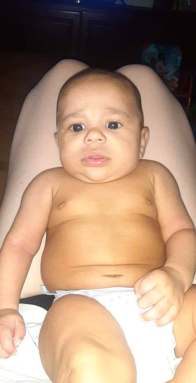 Malachai is registered to the contest to win money with this photo: baby, cheek, chin, eye, eyebrow, facial_expression, hairstyle, hand, human_body, joint, lip, mouth, muscle, neck, nose, person, shoulder, skin, standing, stomach