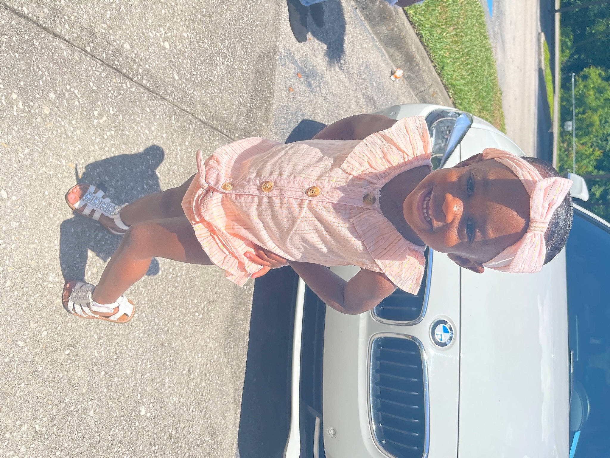 Emeri is registered to the contest to win money with this photo: automotive_exterior, automotive_lighting, blue, bumper, electric_blue, eyewear, fun, goggles, hat, hood, human_leg, joy, luxury_vehicle, motor_vehicle, person, recreation, shorts, sneakers, street_fashion, vehicle