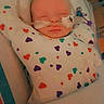 baby, infant, hospital, medical_tubes, blanket, heart_pattern, sleeping, patient, child, face, bed, healthcare, newborn, swaddled, cute, resting, person, indoors, vital_signs, care