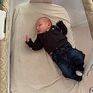 Arthur participe au concours pour gagner de l'argent avec cette photo : baby, sleeping, crib, mesh, clothing, jacket, jeans, socks, bed, infant, resting, indoor, person, cute, child, blanket, furniture, toddler, peaceful, young