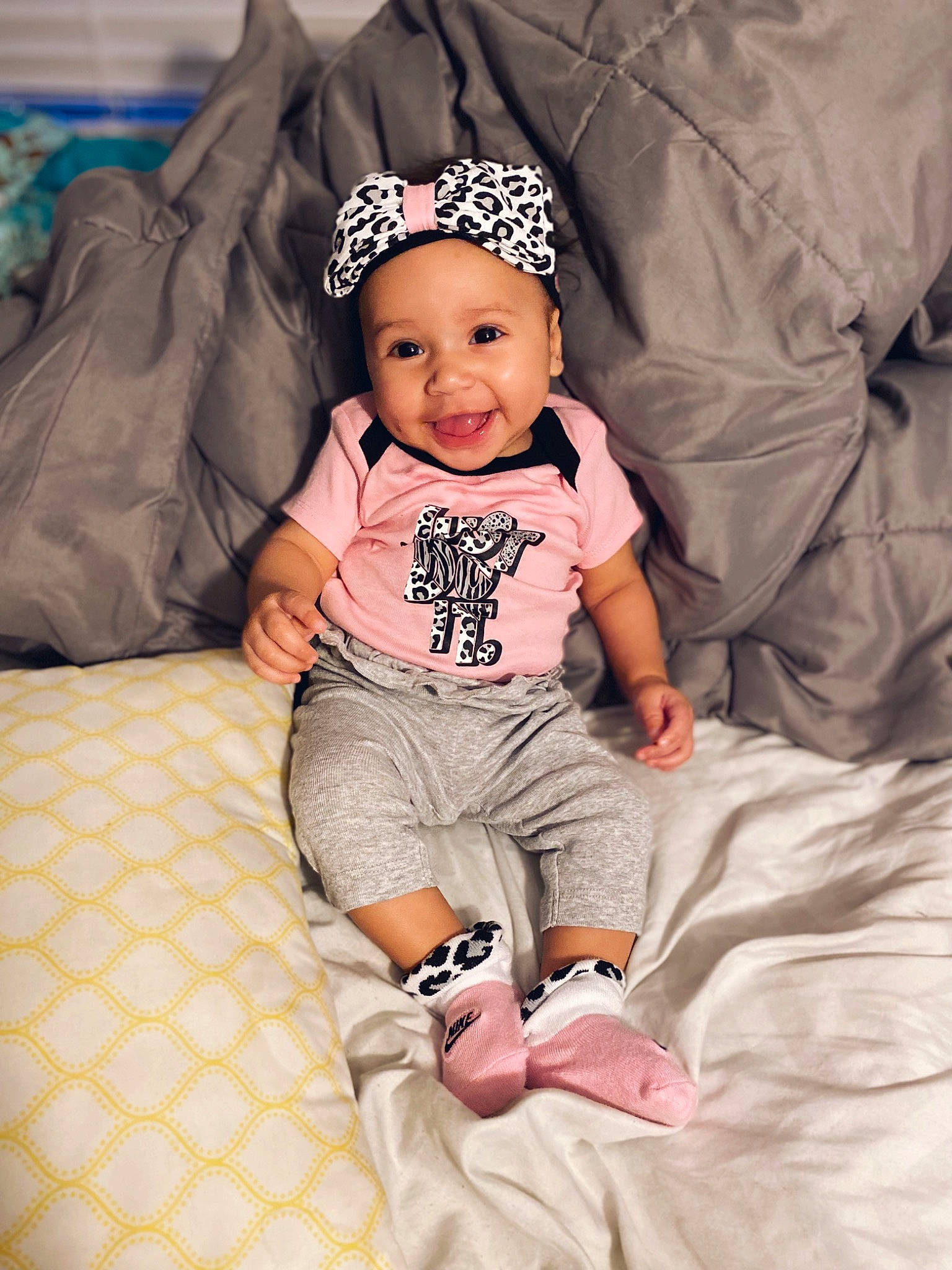 Aiyana is registered to the contest to win money with this photo: arm, baby, baby_toddler_clothing, cap, cheek, child, comfort, eye, face, fun, happy, headwear, joy, pattern, person, pink, skin, sleeve, smile, t_shirt