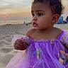 baby, child, toddler, portrait, beach, seaside, ocean, sunset, sand, purple_dress, tutu, floral_embroidery, curly_hair, looking_away, sitting, outdoors, travel, shoreline, colorful_clothing, happy