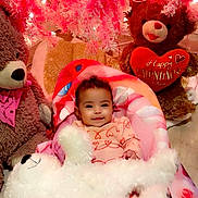 Saphira is registered to the contest to win money with this photo: baby, infant, child, smiling, portrait, valentines_day, teddy_bear, stuffed_animal, pink, red, heart, blanket, crib, sitting, indoor, holiday, festive, cozy, plush, photography