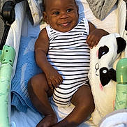 Leeroy a rejoint le concours — aidez-le/la à gagner de superbes lots ! baby, infant, smiling, striped_onesie, panda_plushie, blanket, stroller, cozy, happy, cute, child, soft_toy, comfort, indoors, portrait, relaxed, skin, feet, hand, face