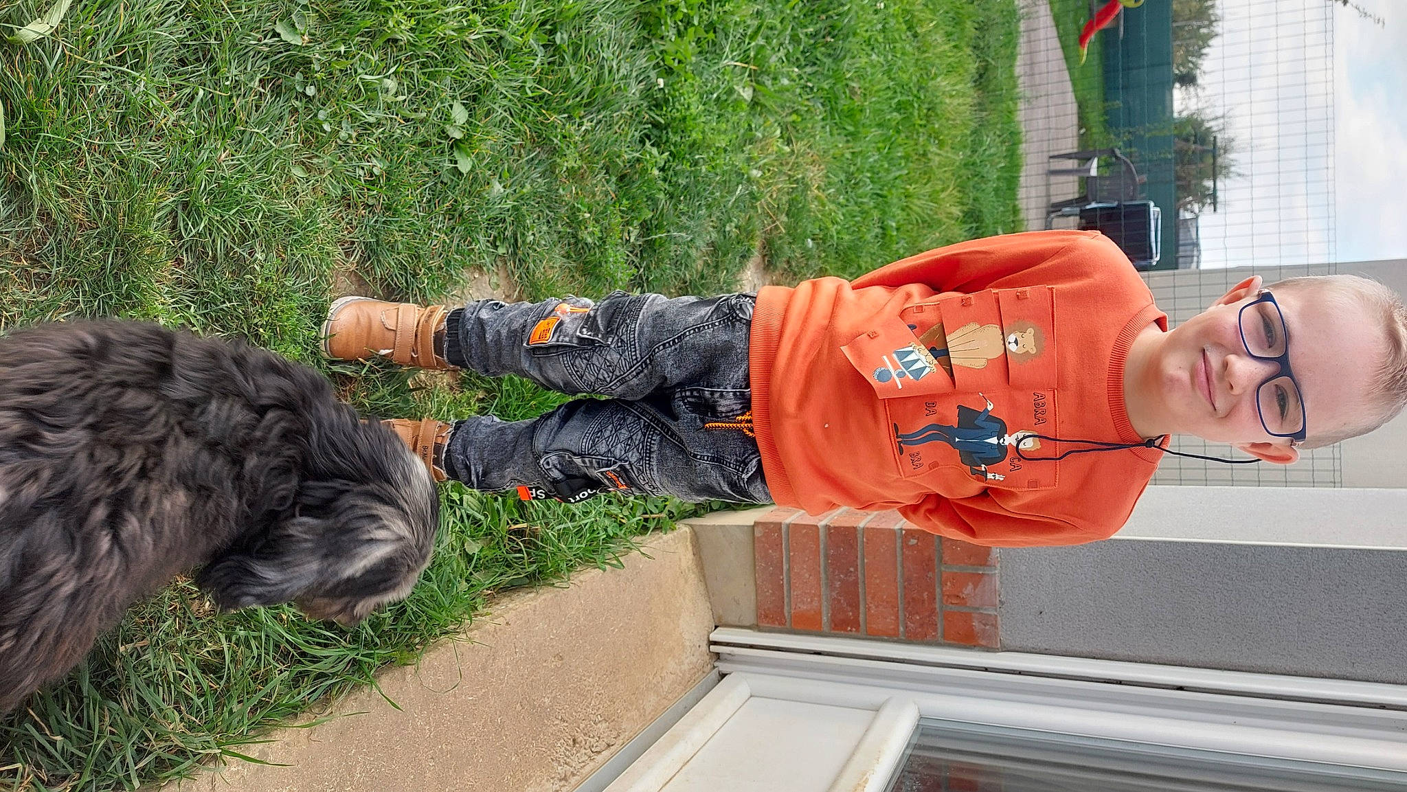 Zac participe au concours pour gagner de l'argent avec cette photo : fur, grass, groundcover, hat, joy, leisure, orange, person, plant, shrub, sidewalk, sitting, smile, soil, tail, toddler, tree, walking_shoe