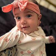 Joelle joined the competition — help win amazing prizes! baby, infant, headband, pink_bow, onesie, peach_prints, closeup, portrait, cute, soft_lighting, indoor, child, smiling, face, eyes, expression, young, adorable, cozy, baby_clothes