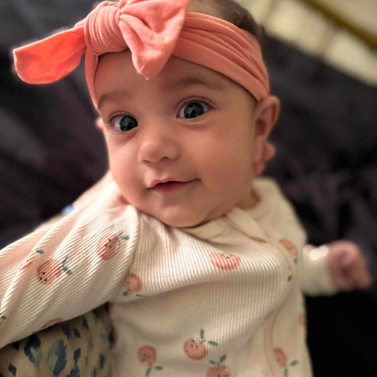 Joelle joined the competition — help win amazing prizes! adorable, baby, baby_clothes, child, closeup, cozy, cute, expression, eyes, face, headband, indoor, infant, onesie, peach_prints, pink_bow, portrait, smiling, soft_lighting, young