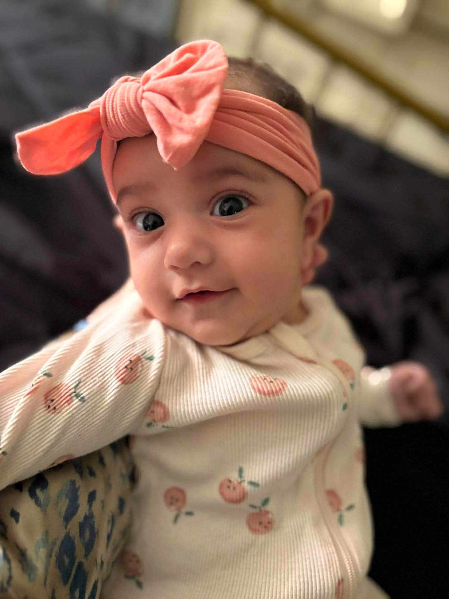 Joelle joined the competition — help win amazing prizes! baby, infant, headband, pink_bow, onesie, peach_prints, closeup, portrait, cute, soft_lighting, indoor, child, smiling, face, eyes, expression, young, adorable, cozy, baby_clothes
