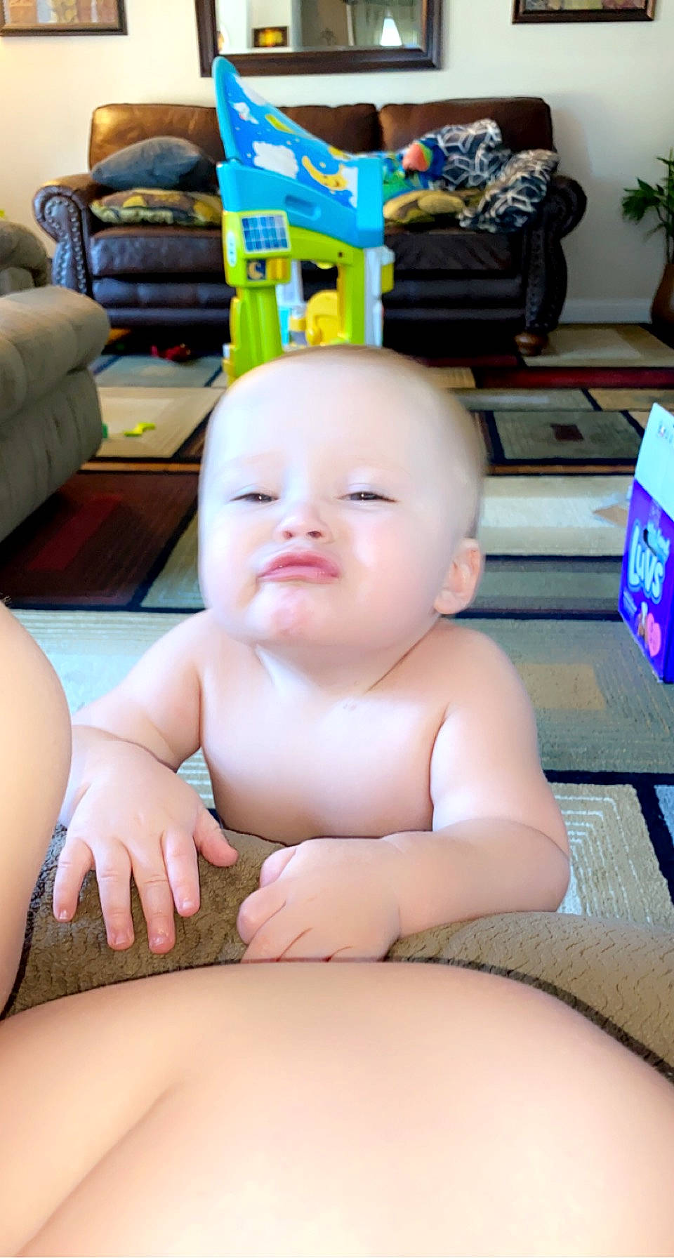 Joziah is registered to the contest to win money with this photo: baby, blue, cheek, child, comfort, facial_expression, finger, flooring, fun, human_body, leg, leisure, mouth, person, sitting, skin, thigh, thumb, toddler, toy