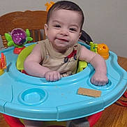 Kyren is registered to the contest to win money with this photo: activity_walker, baby, chair, child, clothing, cracker, face, family_photo, happy, high_chair, home, indoor, infant, playtime, portrait, sitting, smiling, socks, toy, wooden_floor