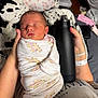 arm, baby, bed, blanket, comfort, cozy, fabric, giraffe_pattern, hand, hospital_bracelet, indoor, infant, newborn, person, pillow, resting, sleeping, soft_lighting, swaddled, water_bottle