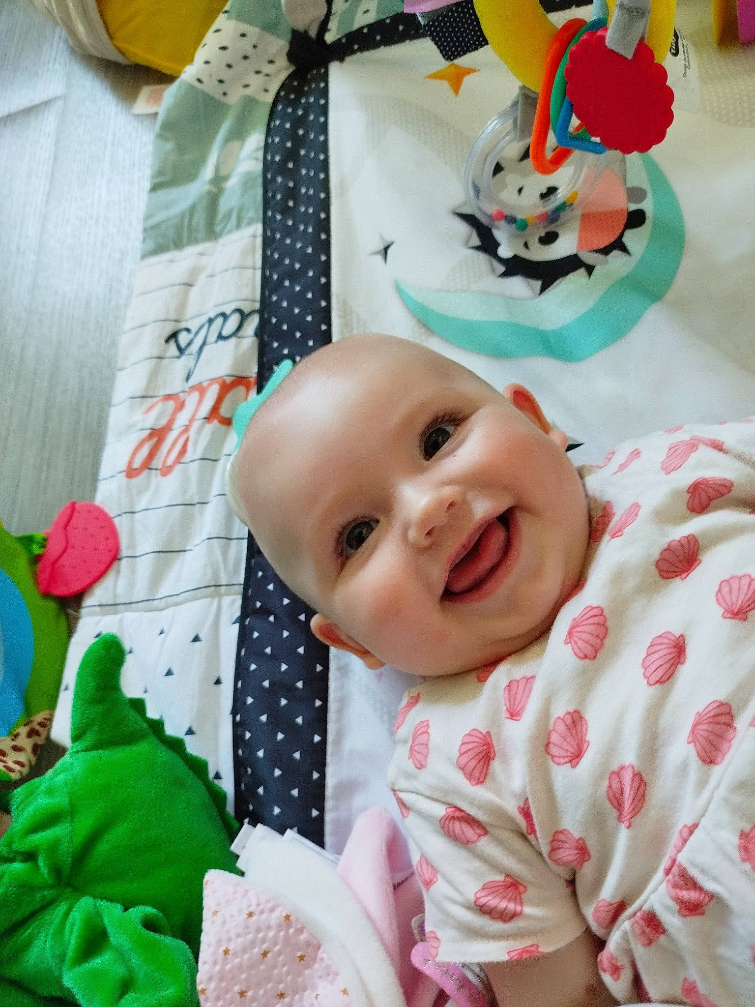 Lola a rejoint le concours — aidez-le/la à gagner de superbes lots ! baby, baby_laughing, baby_products, baby_toddler_clothing, cheek, child, event, fun, green, happy, joy, linens, pattern, person, pink, room, smile, textile, toddler, toy