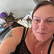 Gizmo And Nala joined the competition — help win amazing prizes! woman, cat, tattoo, necklace, cross, red_collar, tabby_cat, smile, face, indoor, home_decor, blanket, reindeer, furniture, curious, shoulder, portrait, person, expression, casual