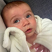 Sarahlouisejasmine is registered to the contest to win money with this photo: baby, infant, face, eyes, blanket, white, soft, skin, expression, curious, close_up, portrait, hand, couch, furniture, indoors, child, young, cozy, warm