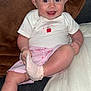 baby, blanket, child, couch, cozy, cute, face, foot, hand, happy, indoor, infant, pillow, pink, shirt, shorts, sitting, smiling, sock, white