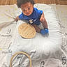 baby, child, milestone_blanket, blue_clothing, socks, wooden_plaque, wooden_ring, floor, vent, curly_hair, sitting, indoor, portrait, looking_up, milestone, home, flooring, cute, person, infant