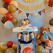 Rishi joined the competition — help win amazing prizes! baby, high_chair, birthday_cake, balloons, teddy_bear, party_hat, celebration, first_birthday, smiling, child, indoor, decorations, banner, floor, wooden_floor, toy, cute, happy, one_year_old, festive