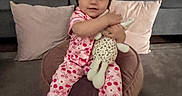 Mykenzie joined the competition — help win amazing prizes! carpet, casual, child, couch, cozy, cute, giraffe_toy, home, indoor, living_room, pajamas, person, pillows, pink_clothing, plush_toy, sitting, smiling, soft_furniture, toddler, young_child
