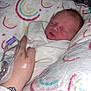 newborn, baby, blanket, swaddled, sleeping, hand, hospital, iv_line, wristband, tattoo, pillow, rainbow_pattern, skin, person, medical, resting, infant, cute, comfort, tender
