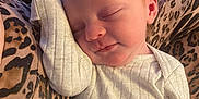 Lily joined the competition — help win amazing prizes! baby, newborn, sleeping, white_onesie, infant, cozy, leopard_print, blanket, peaceful, cute, child, face, skin, head, ear, arm, hand, rest, indoors, soft