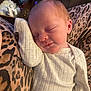 baby, newborn, sleeping, white_onesie, infant, cozy, leopard_print, blanket, peaceful, cute, child, face, skin, head, ear, arm, hand, rest, indoors, soft