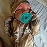 baby, pacifier, camouflage, clothing, hood, infant, sleepy, bed, blanket, soft, cute, newborn, person, portrait, lying_down, cozy, child, small, warm, comfort
