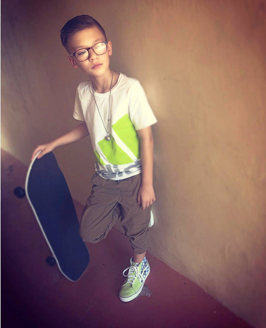 Kevin is registered to the contest to win money with this photo: child, cool, eyewear, fashion, footwear, fun, glasses, green, head, human, joint, light, male, person, shoe, sky, smile, standing, t_shirt, white