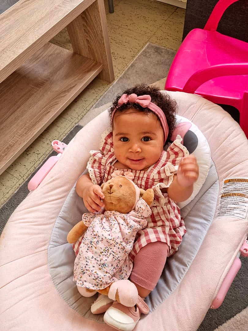 Daniella participe au concours pour gagner de l'argent avec cette photo : baby, baby_products, baby_toddler_clothing, child, comfort, event, facial_expression, fun, hairstyle, happy, hardwood, head, lap, leisure, magenta, person, pink, sitting, skin, toddler