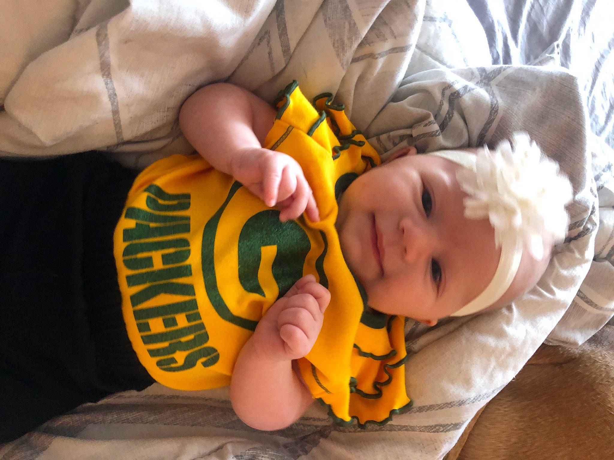 Bexlee is registered to the contest to win money with this photo: arm, baby, baby_products, baby_toddler_clothing, child, comfort, eye, finger, gesture, hand, headwear, human_body, linens, nail, orange, person, product, room, sleeve, thumb