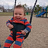 baby, child, swing, playground, smiling, happy, outdoor, park, clothing, striped, seat, grass, bench, slide, person, fun, daytime, nature, tree, joy