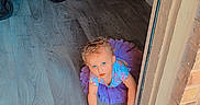 Renezmae joined the competition — help win amazing prizes! toddler, child, crawling, doorway, purple_tutu, blue_eyes, stroller, red_clothing, wooden_floor, indoor, outdoor, brick_wall, concrete_step, curious, baby, person, flooring, casual, playful, home_interior