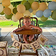 Renezmae is registered to the contest to win money with this photo: baby, high_chair, birthday, balloons, banner, winnie_the_pooh, party, outdoor, child, celebration, wooden_chair, decorations, tablecloth, grass, sunlight, cute, one_year_old, event, childrens_party, infant