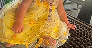 Renezmae joined the competition — help win amazing prizes! toddler, child, yellow_dress, pacifier, picnic_table, park, playground, bottle, person, outdoor, pavilion, summer, daylight, clothing, sitting, baby, expression, face, hand, foot