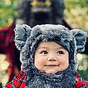 Aurelio Sebastian joined the competition — help win amazing prizes! baby, child, costume, wolf, fluffy, fur, hat, ears, smile, face, portrait, red_plaid, clothing, person, outdoor, nature, blurred_background, cute, playful, holiday