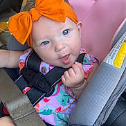 Melinna Mae is registered to the contest to win money with this photo: baby, car_seat, orange_bow, blue_eyes, child, seatbelt, colorful_clothing, infant, cheeky_expression, car_interior, safety_harness, cute, portrait, seat, headband, young_child, smiling, person, indoors, closeup