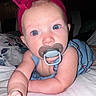 Melinna Mae is registered to the contest to win money with this photo: baby, pacifier, headband, blue_eyes, infant, bed, arm, skin, clothing, indoor, person, cute, young_child, portrait, child, face, expression, reaching, laying, closeup
