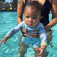 Khari is registered to the contest to win money with this photo: toddler, child, baby, pool, water, swimwear, adult, tattoo, sunlight, outdoor, summer, holding, cute, serious_face, swimming, parent, family, skin, daytime, recreation