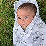 animal_print, baby, baby_clothes, blanket, child, cute, face, grass, head, infant, lying_down, nature, newborn, outdoor, peaceful, portrait, soft, wide_eyes, wrapped, young