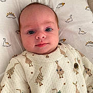 Lucie a rejoint le concours — aidez-le/la à gagner de superbes lots ! baby, infant, face, eyes, clothing, pattern, dinosaur, bird, cushion, fabric, cute, portrait, child, soft, indoor, newborn, expression, laying, apparel, button