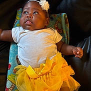 Legacy joined the competition — help win amazing prizes! baby, child, infant, portrait, sitting, chair, colorful, yellow_tutu, white_shirt, flower_headband, headband, fashion, cute, looking_away, indoor, close_up, dark_background, baby_clothing, smiling, photography