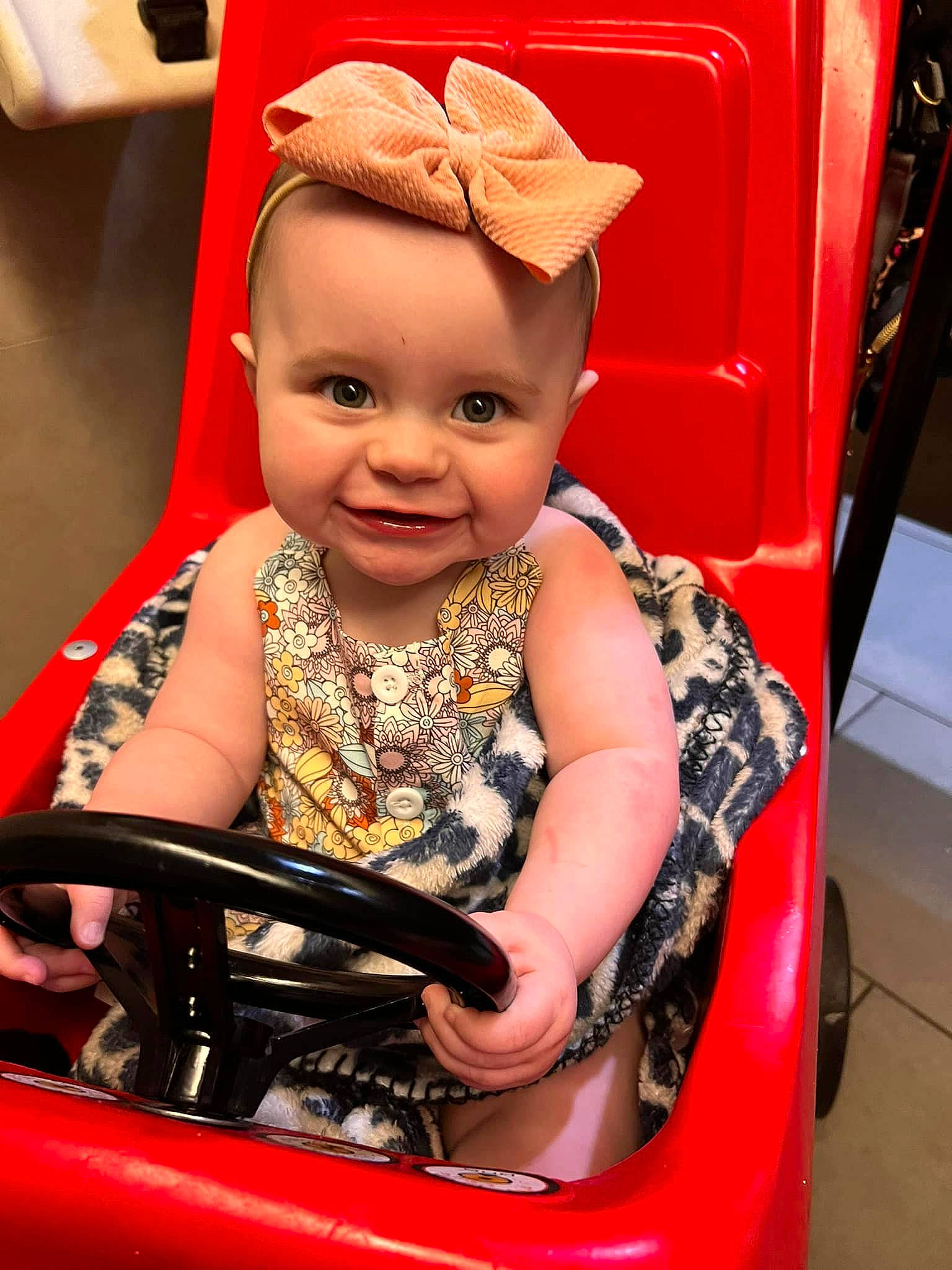 Katalina is registered to the contest to win money with this photo: automotive_design, baby, baby_carriage, eye, facial_expression, fun, happy, hood, joy, motor_vehicle, person, photograph, pink, product, red, skin, smile, snapshot, tire, toddler