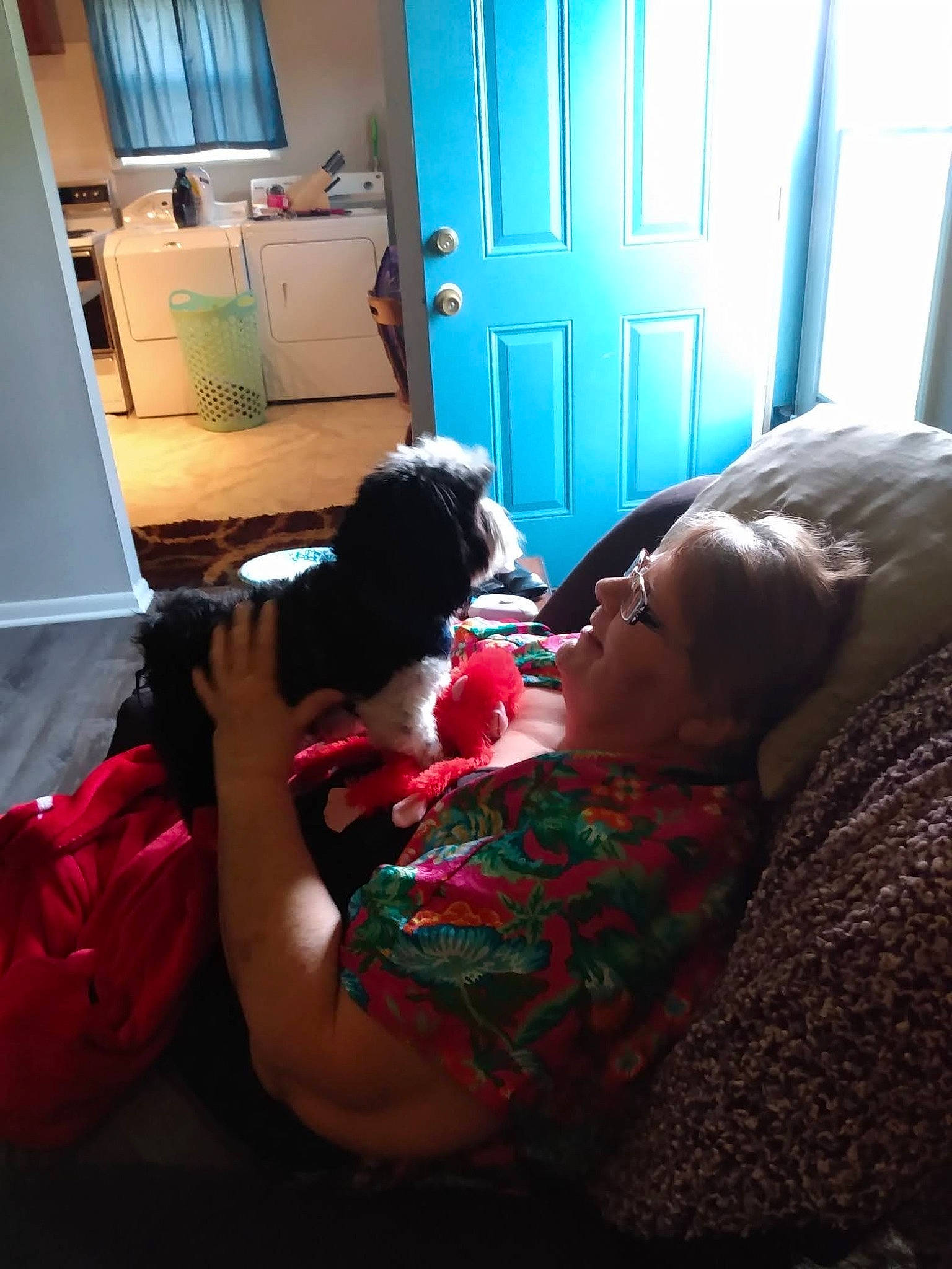 Blue is registered to the contest to win money with this photo: bedroom, box, chest_of_drawers, child, comfort, cupboard, drawer, eyewear, flooring, fun, lamp, linens, living_room, mammal, nap, room, shipping_box, sitting, toy, vertebrate