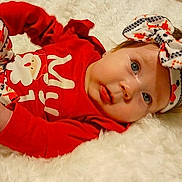 Azaria joined the competition — help win amazing prizes! baby, infant, red_clothing, headband, bow, blue_eyes, lying_down, fluffy_surface, cute, child, festive, holiday_outfit, portrait, person, soft_texture, indoor, face, expression, newborn, adorable