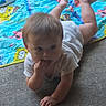 Sebastian is registered to the contest to win money with this photo: baby, brown_hair, carpet, cartoon, child, colorful, crawling, curious, face, fingers, floor, hands, home, indoor, play_mat, playtime, portrait, sitting, toy, white_shirt