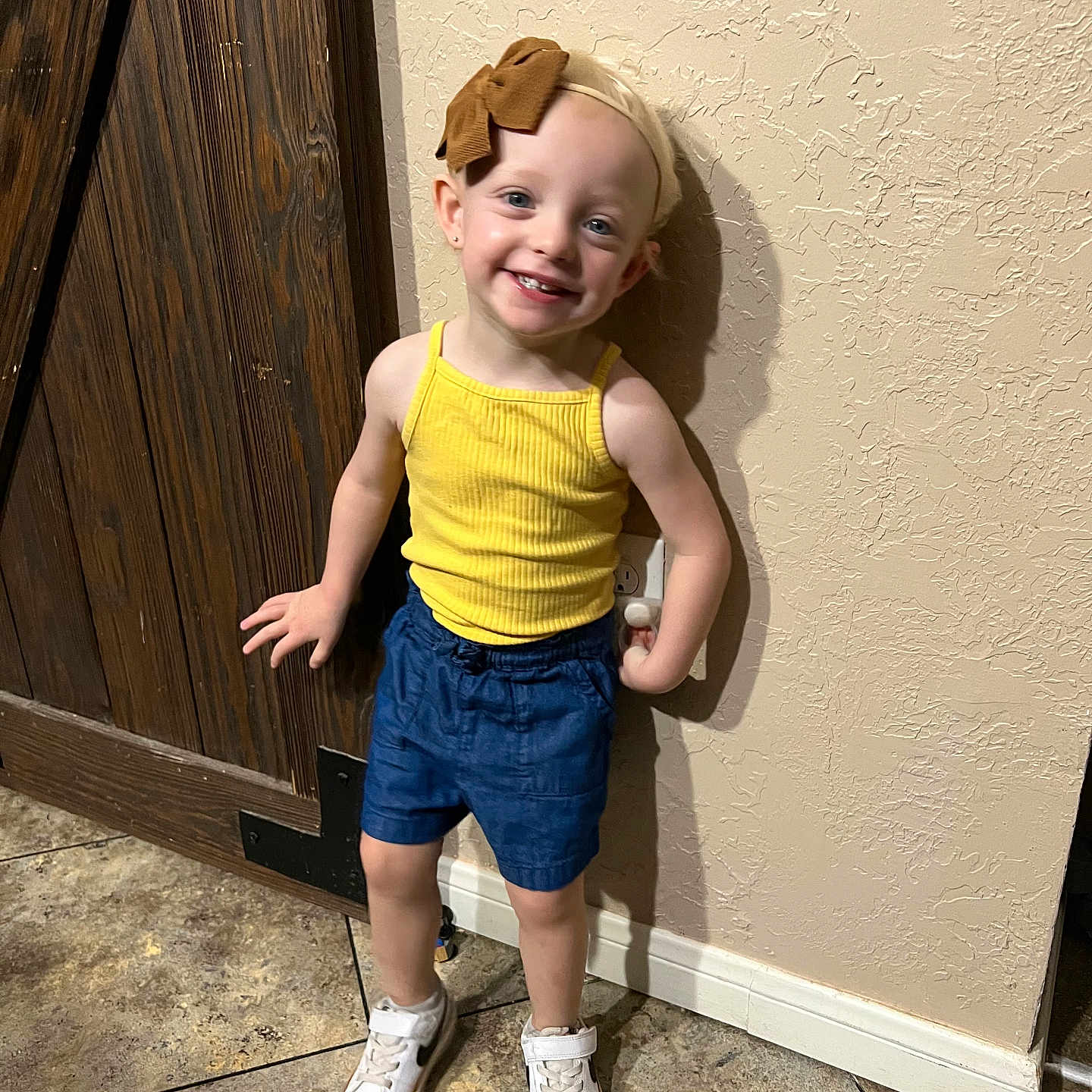 Charlee is registered to the contest to win money with this photo: child, clothing, door, face, female, footwear, girl, happy, hardwood, head, jeans, pants, person, photography, portrait, shoe, shorts, sneaker, standing, wood