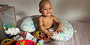 Neithan participe au concours pour gagner de l'argent avec cette photo : baby, child, smile, toy, pillow, bed, stuffed_animal, sock, indoor, playtime, infant, colorful, happy, cute, nursing_pillow, round_toy, soft_toy, clothing, person, room